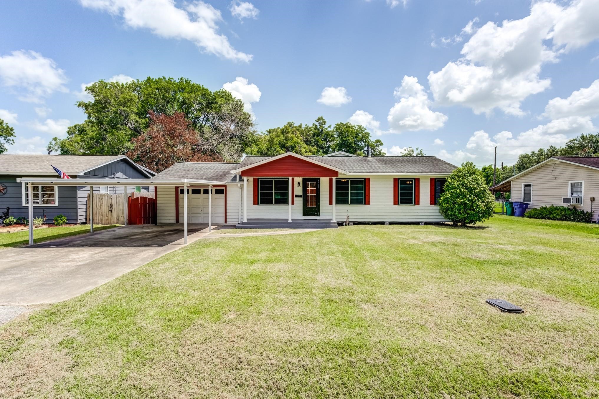 305 Yaupon Street Sweeny, TX 77480 - Photo 15 of 22 Charming single-story home with a vibrant red accent, featuring a welcoming front porch, attached carport, and a spacious, well-maintained lawn. Ideal for comfortable living in a serene neighborhood setting.