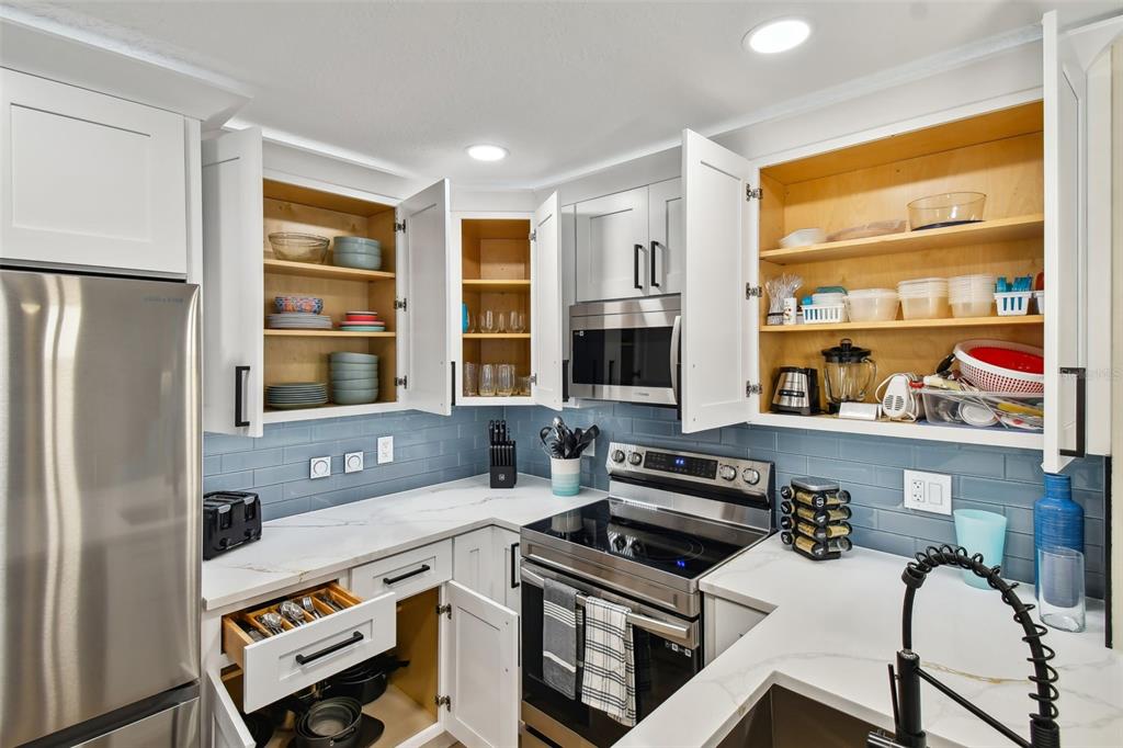 315 Medallion Boulevard, Unit E Madeira Beach, FL 33708 - Photo 28 of 78 a kitchen with a stove a refrigerator and a sink