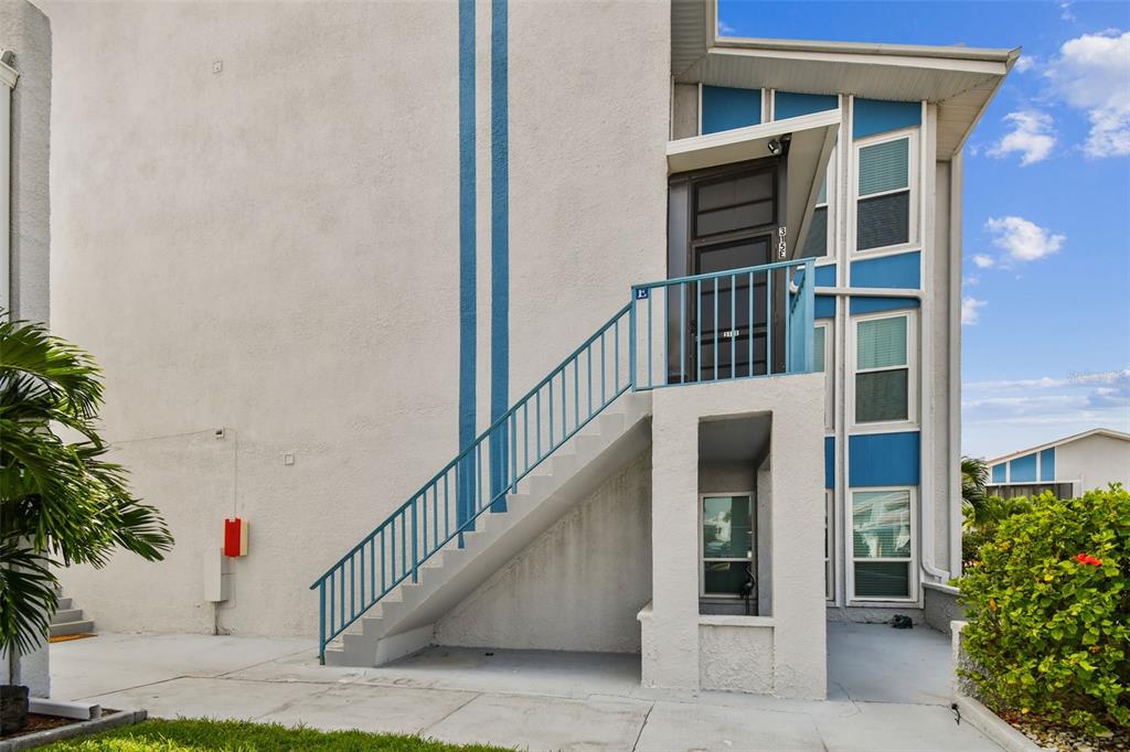 315 Medallion Boulevard, Unit E Madeira Beach, FL 33708 - Photo 3 of 78 a view of staircase with railing and potted plants