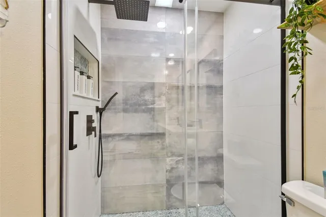 a room with furniture a window and a glass door shower