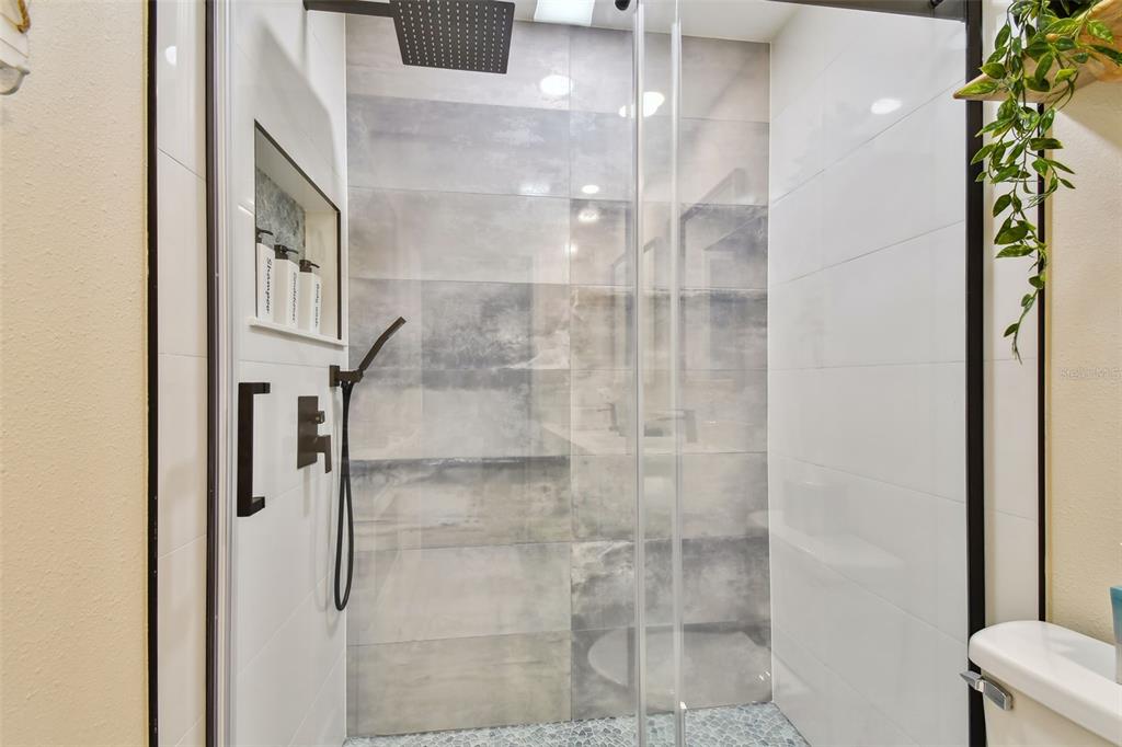 315 Medallion Boulevard, Unit E Madeira Beach, FL 33708 - Photo 34 of 78 a bathroom with a glass shower door