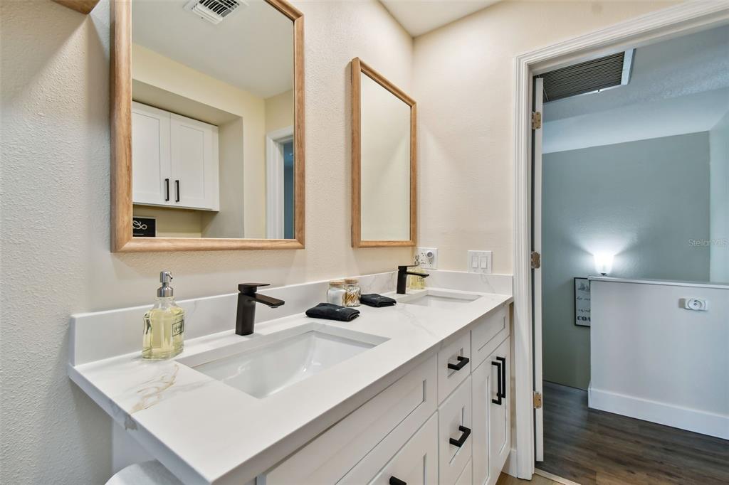 315 Medallion Boulevard, Unit E Madeira Beach, FL 33708 - Photo 35 of 78 a bathroom with double sink and two mirror