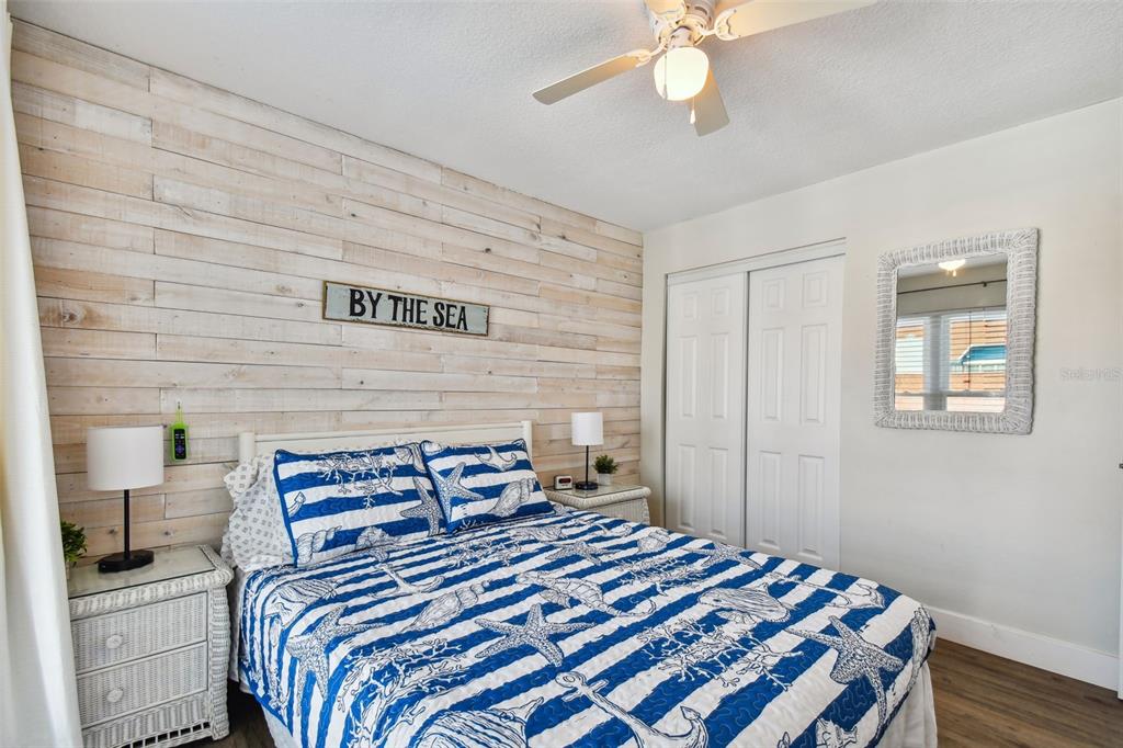 315 Medallion Boulevard, Unit E Madeira Beach, FL 33708 - Photo 38 of 78 a bedroom with a bed and a chandelier
