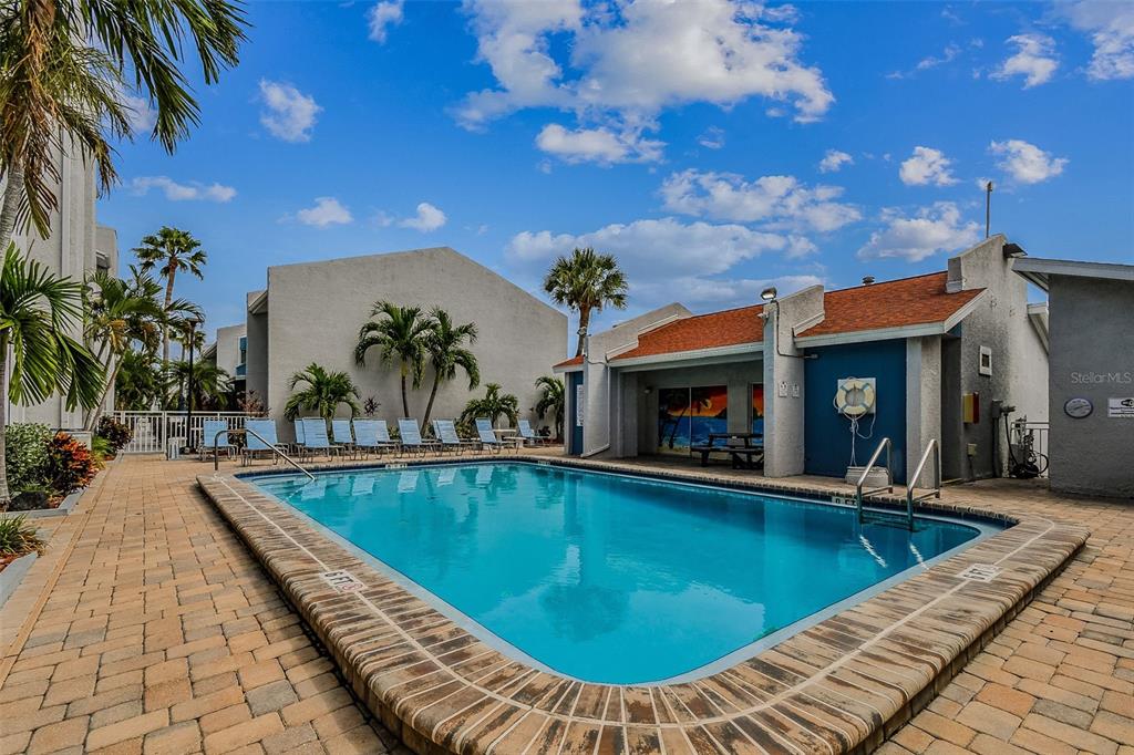 315 Medallion Boulevard, Unit E Madeira Beach, FL 33708 - Photo 57 of 78 a view of a swimming pool with a patio
