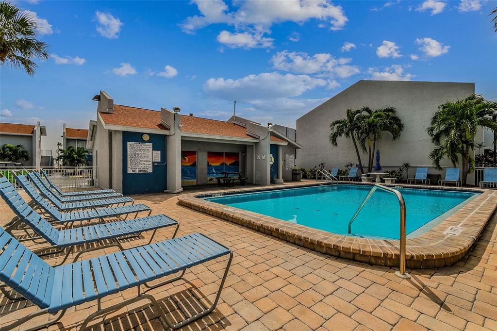 315 Medallion Boulevard, Unit E Madeira Beach, FL 33708 - Photo 58 of 78 a view of a patio with swimming pool table and chairs