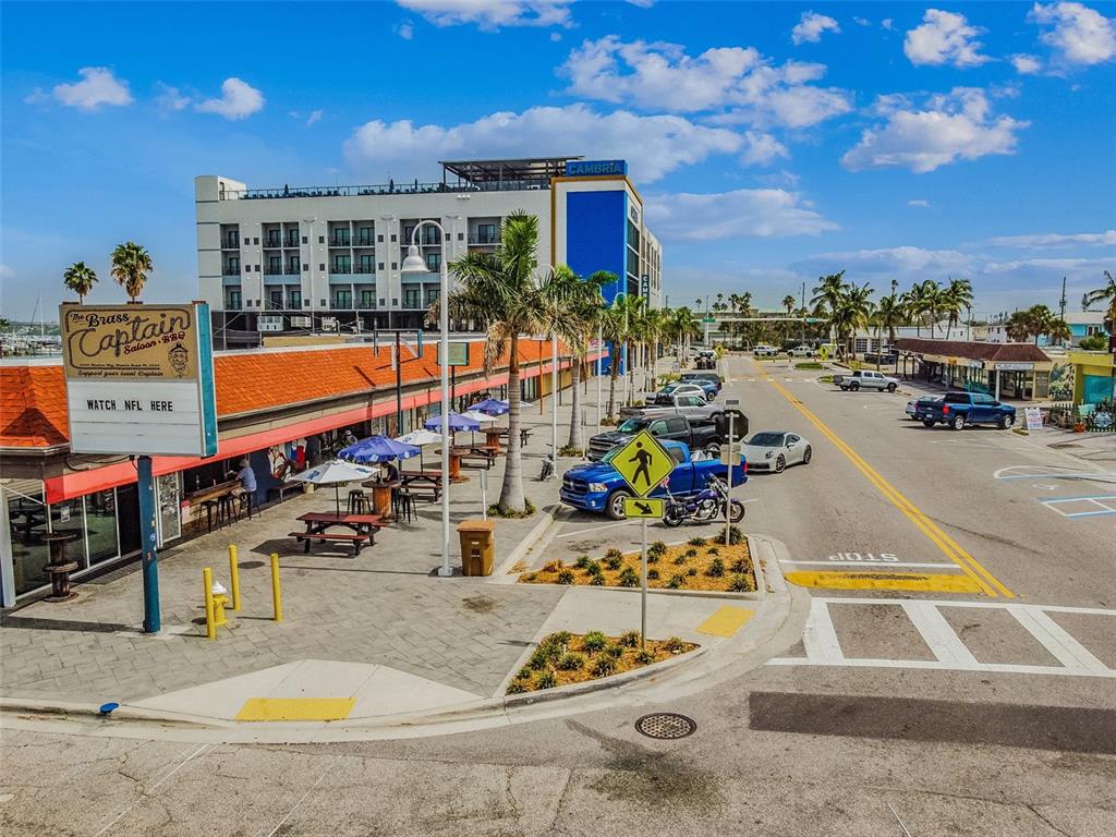 315 Medallion Boulevard, Unit E Madeira Beach, FL 33708 - Photo 66 of 78 a view of a swimming pool with a lounge chairs