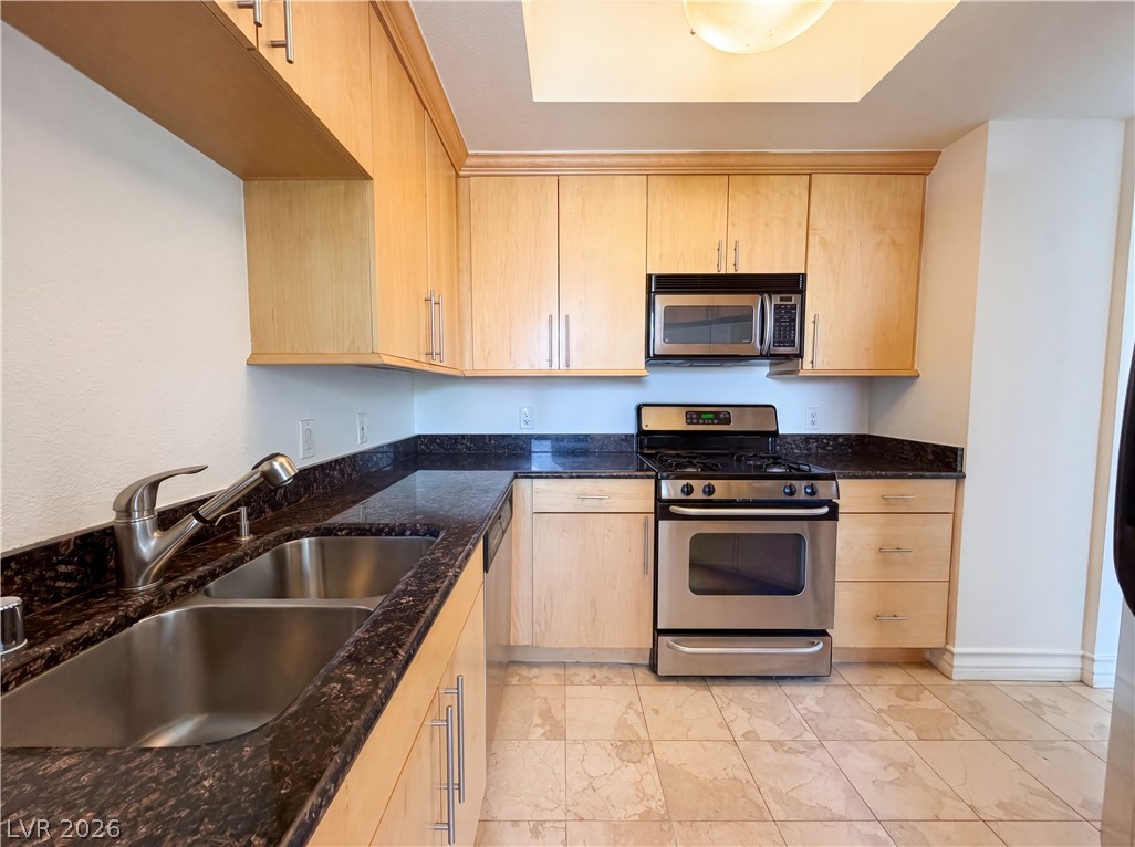 230 East Flamingo Road, Unit 320 Las Vegas, NV 89169 - Photo 4 of 19 A well-appointed kitchen showcasing light-colored cabinetry and stone countertops.