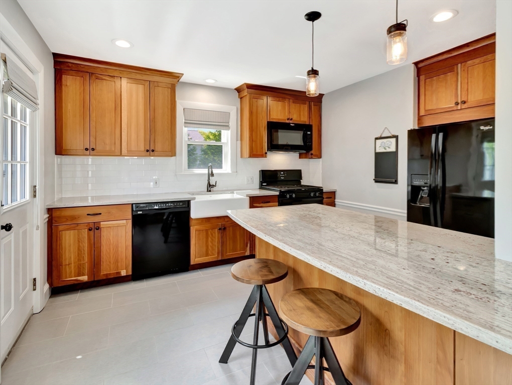 26 C Street Hull, MA 02045 - Photo 20 of 42 a kitchen with stainless steel appliances granite countertop a sink a stove top oven a granite counter space and a refrigerator