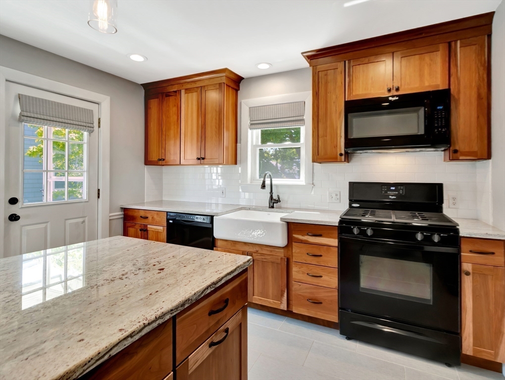 26 C Street Hull, MA 02045 - Photo 21 of 42 a kitchen with stainless steel appliances a stove microwave and sink