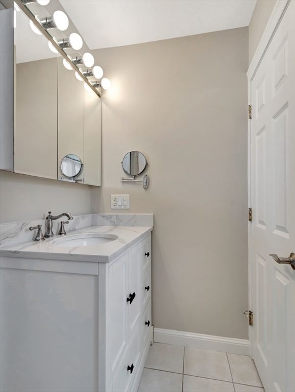26 C Street Hull, MA 02045 - Photo 26 of 42 a bathroom with a granite countertop sink a large mirror and vanity
