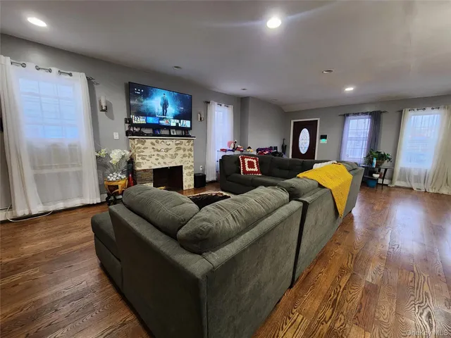 a living room with fireplace furniture and a wooden floor