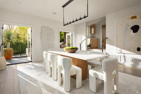 a dining table with chairs and view of kitchen