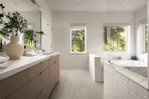 a bathroom with a granite countertop sink a bathtub and window