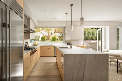 a kitchen with stainless steel appliances granite countertop a sink a stove and a refrigerator