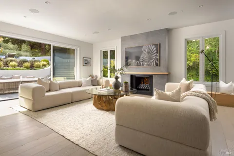 a living room with furniture a large window and a fireplace