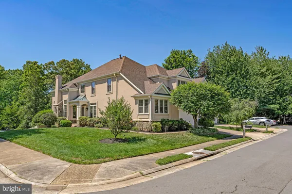 a front view of a house with a yard and trees