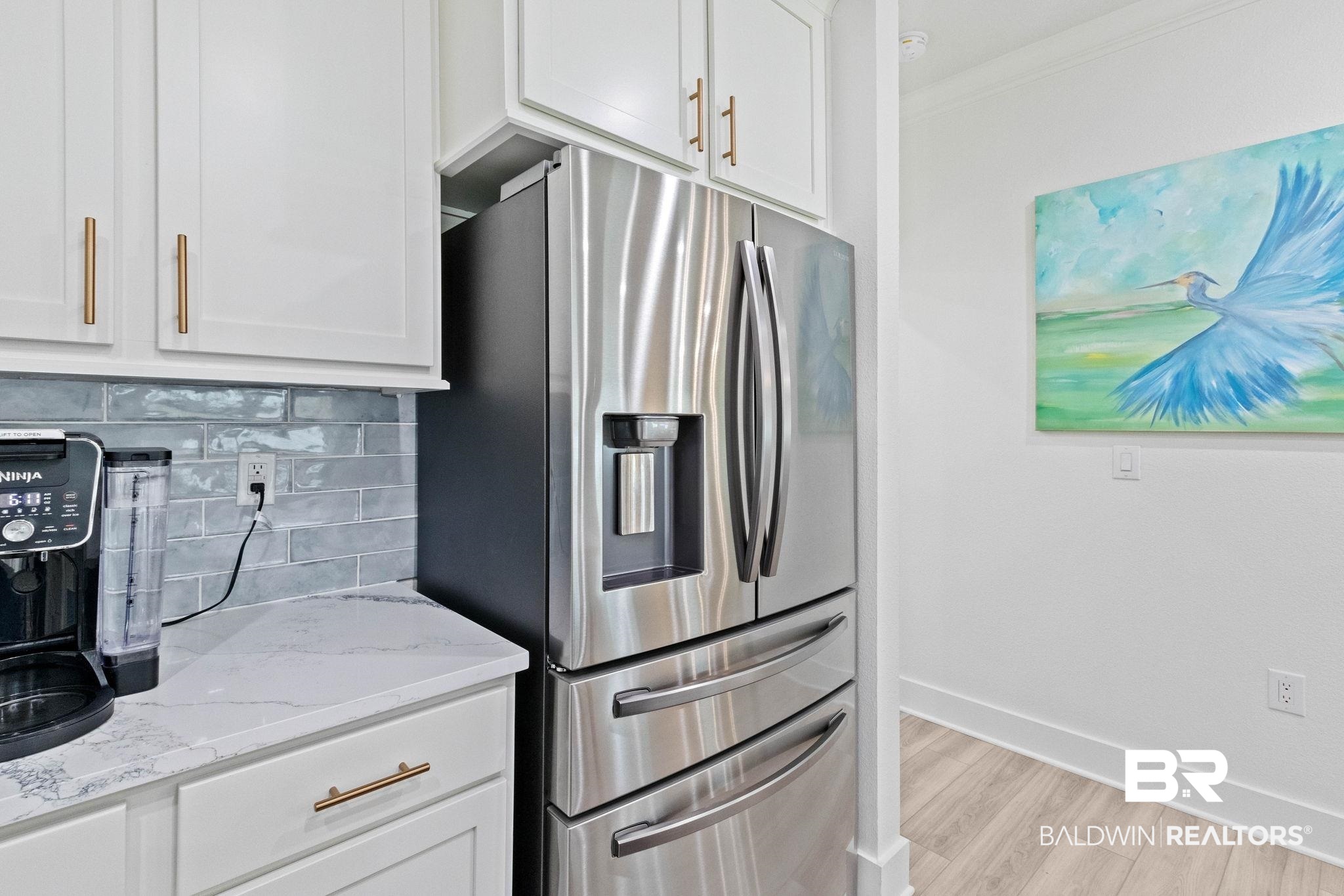 9815 Lakeview Drive Foley, AL 36535 - Photo 27 of 100 Kitchen featuring tasteful backsplash, light wood-type flooring, light stone countertops, stainless steel fridge, and white cabinets