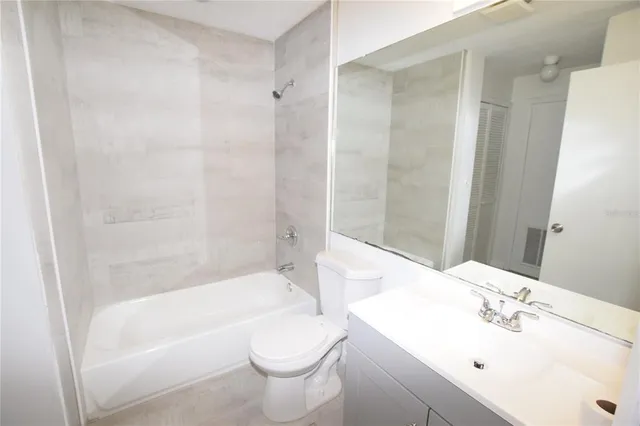a bathroom with a bathtub shower sink vanity and toilet