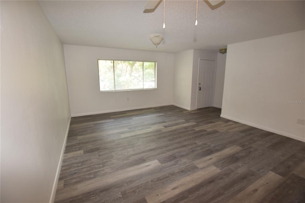 904 Sumter Street Leesburg, FL 34748 - Photo 8 of 27 an empty room with wooden floor and windows