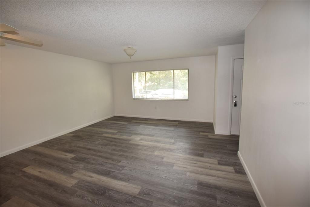 904 Sumter Street Leesburg, FL 34748 - Photo 9 of 27 an empty room with wooden floor and windows