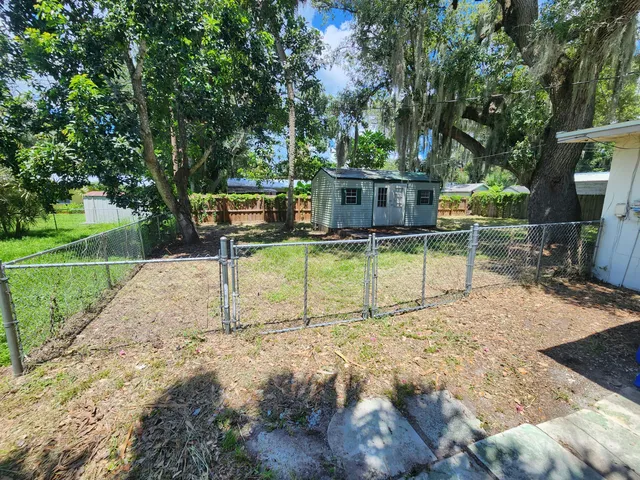 an empty room with wooden floor ceiling fan and windows