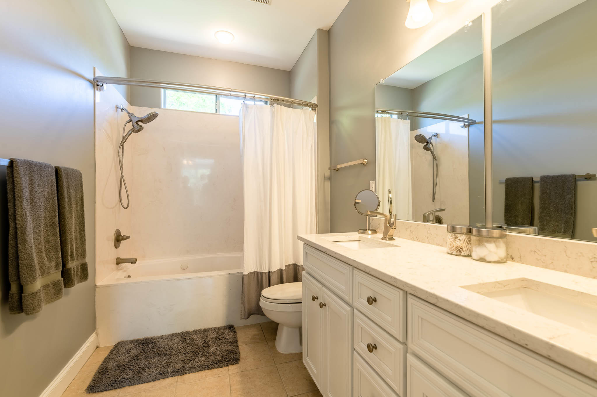2275 Mack Bayou Road Santa Rosa Beach, FL 32459 - Photo 17 of 20 a bathroom with a double vanity sink toilet mirror and shower