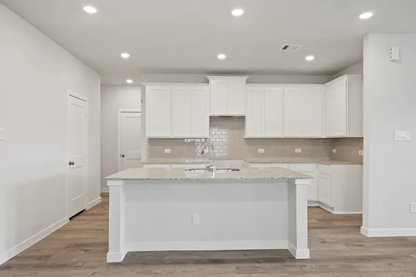 a kitchen with kitchen island stainless steel appliances a sink and cabinets