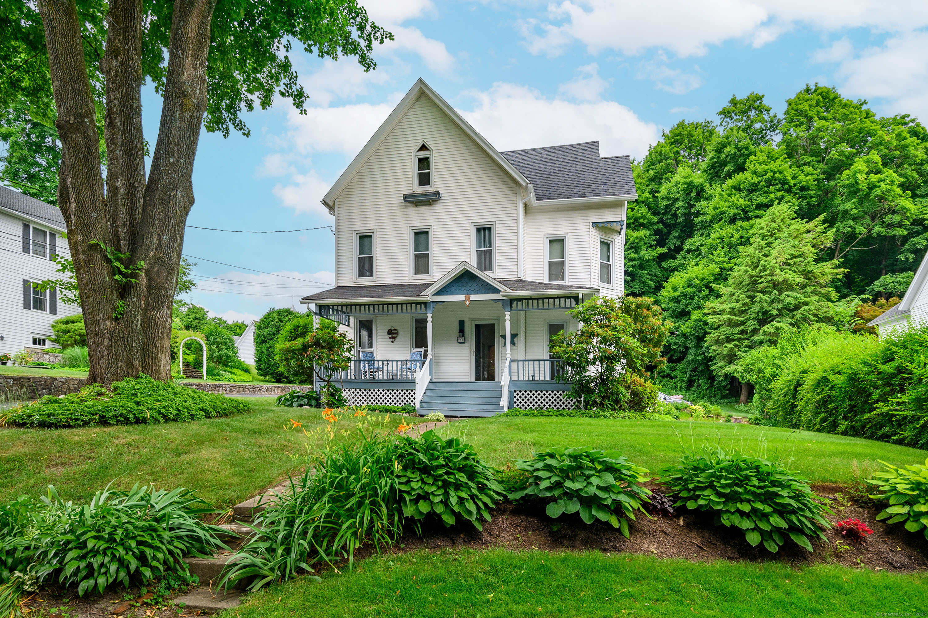 a view of a house with a big yard plants and large trees