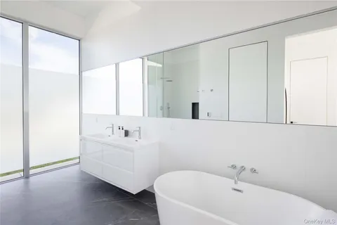 a bathroom with a bathtub a sink a mirror and a shower