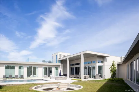 a front view of a house with swimming pool and outdoor seating