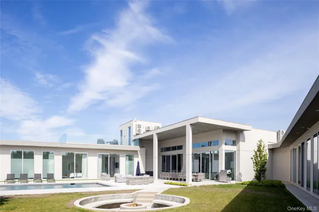 a front view of a house with swimming pool and outdoor seating