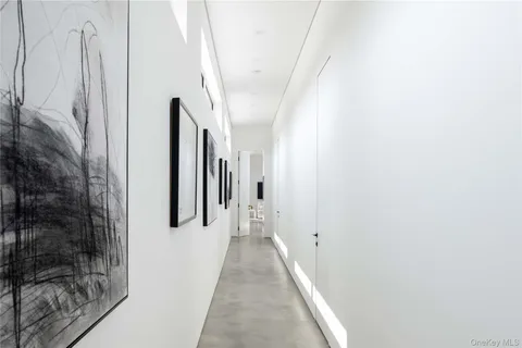 a view of a hallway with white walls and a white door