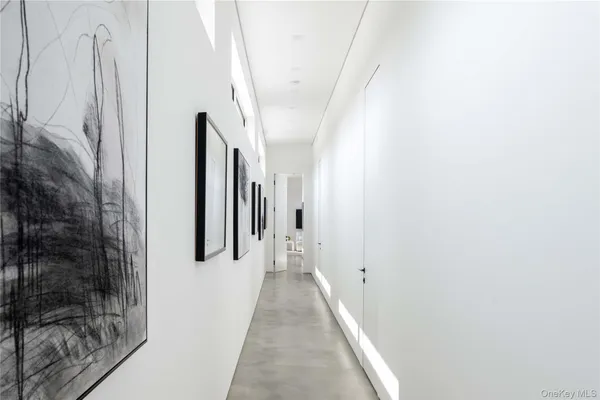 a view of a hallway with white walls and a white door