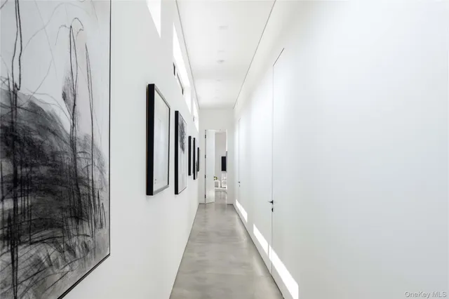 a view of a hallway with white walls and a white door