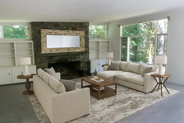 a living room with furniture a large window and a fireplace