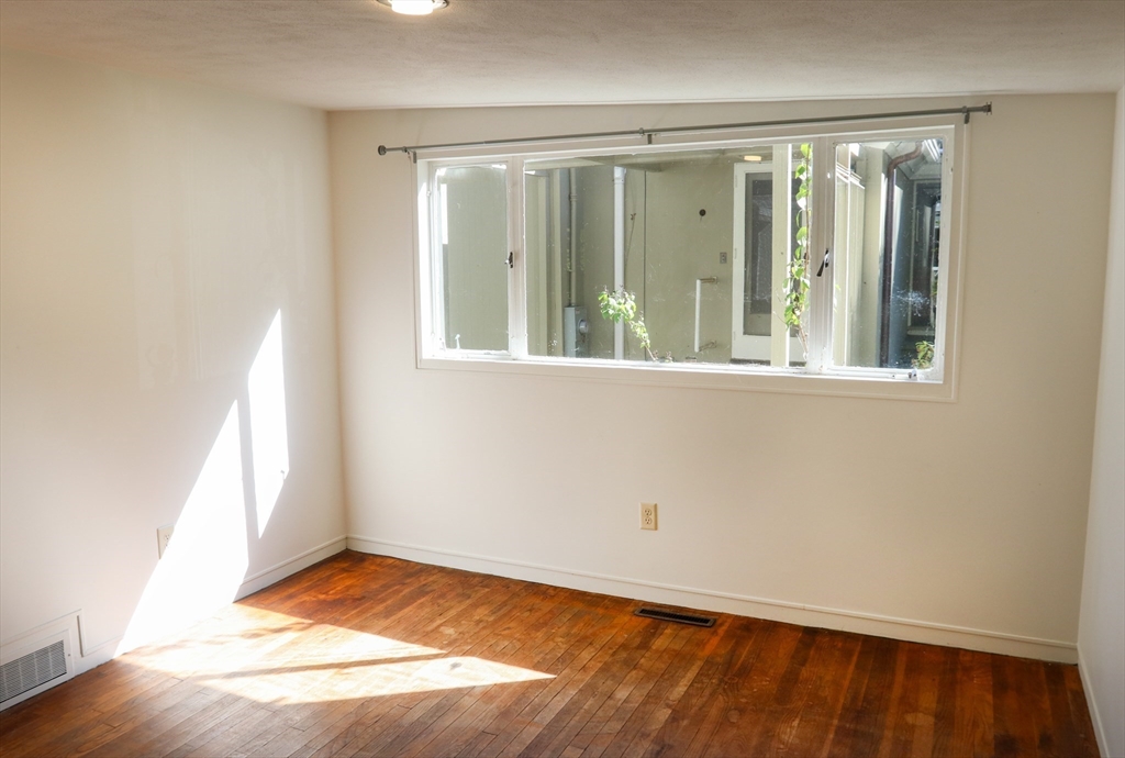 583 Gay Street, Unit A Westwood, MA 02090 - Photo 8 of 14 an empty room with wooden floor and windows