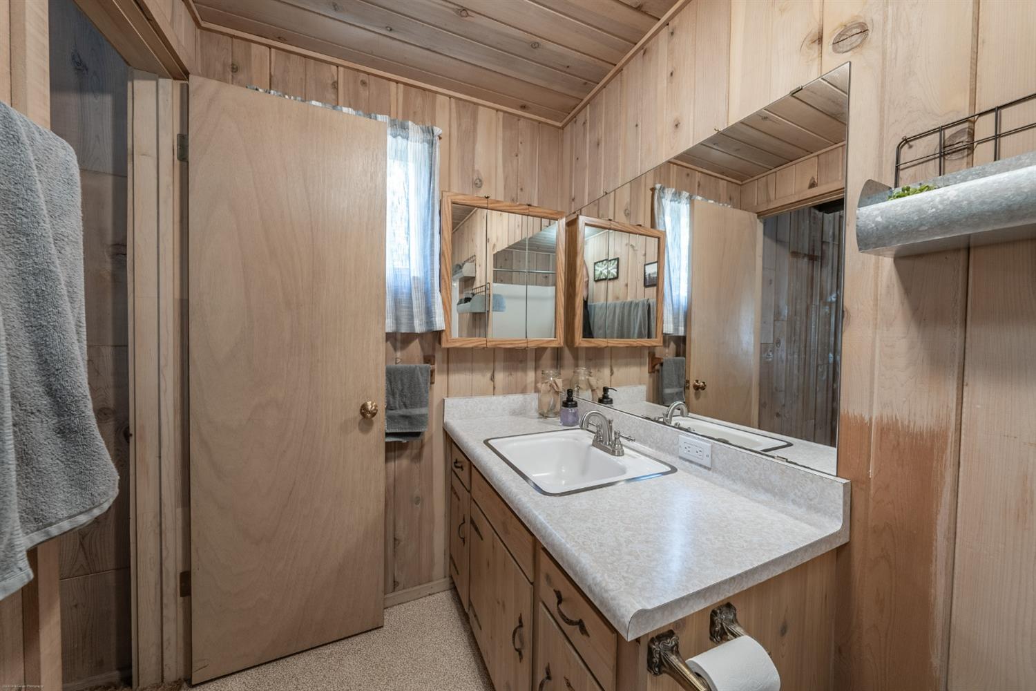 41277 Timber Drive Shaver Lake, CA 93664 - Photo 16 of 24 a bathroom with a sink a mirror and a shower