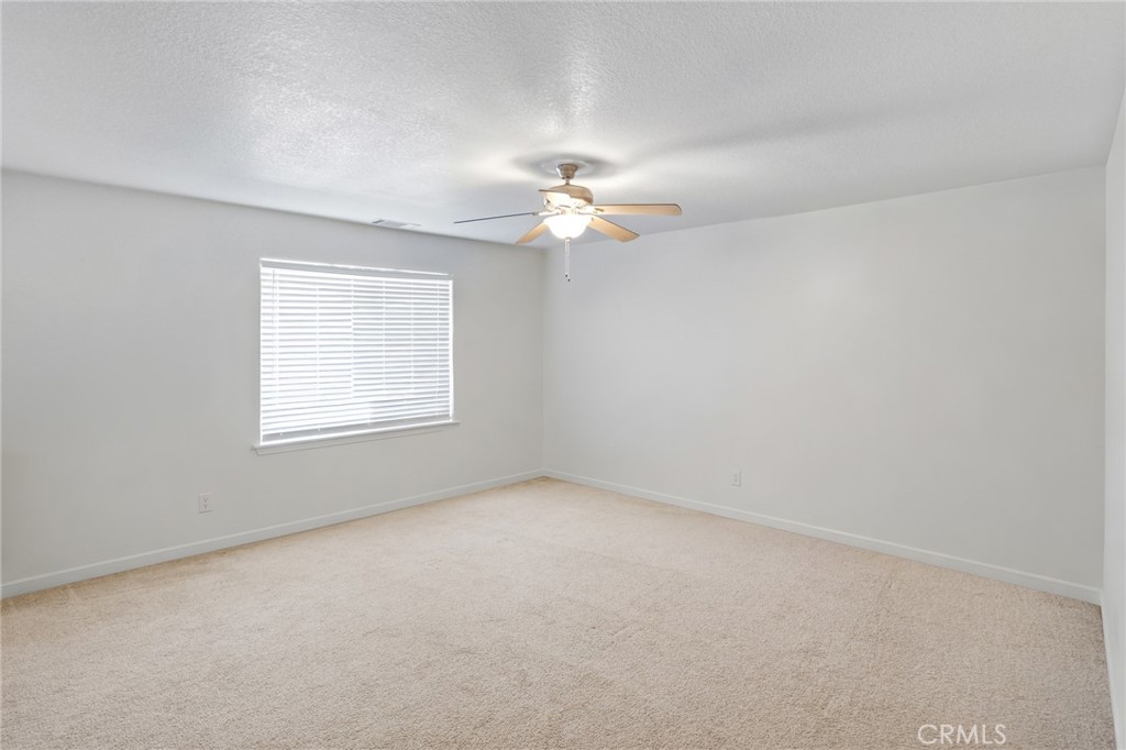 11025 El Esteban Road Phelan, CA 92371 - Photo 20 of 54 an empty room with a window and a ceiling fan