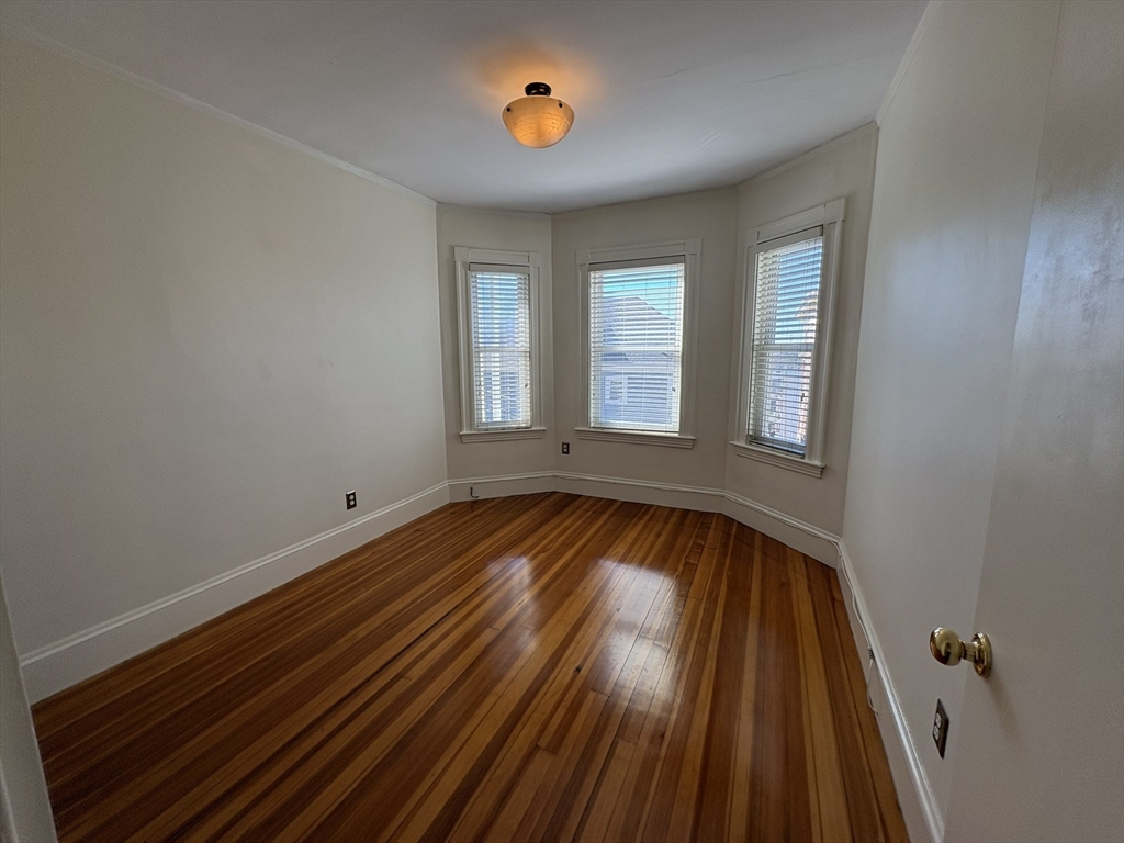 62 Ibbetson Street, Unit 3L Somerville, MA 02143 - Photo 6 of 20 wooden floor in an empty room with a window