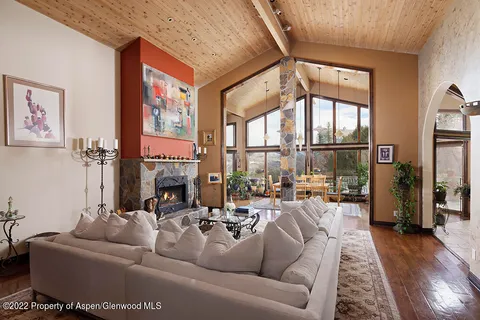 a living room with furniture fireplace and a large window