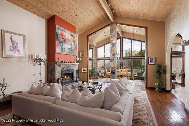 a living room with furniture fireplace and a large window
