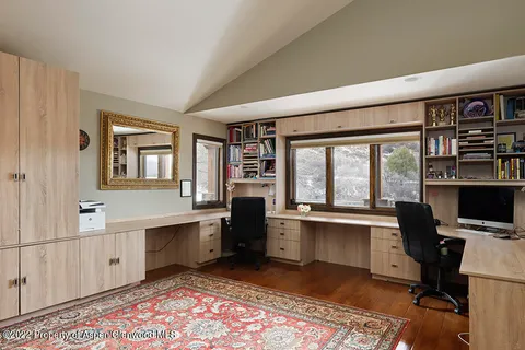 a view of a workspace with furniture and a window