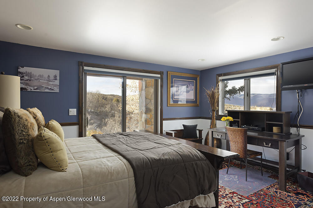 2345 Juniper Hill Road Aspen, CO 81611 - Photo 21 of 26 a bedroom with a bed a large window with table and chairs