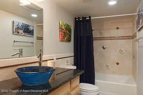 a bathroom with a bathtub shower and toilet