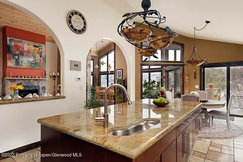a kitchen with a table chairs and a clock on the wall