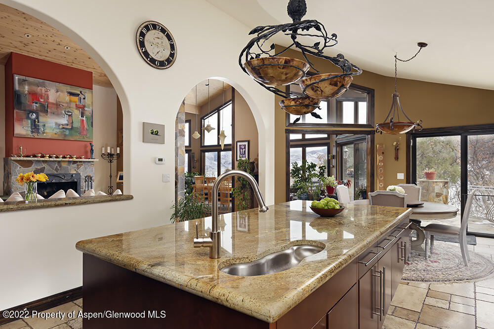 2345 Juniper Hill Road Aspen, CO 81611 - Photo 10 of 26 a kitchen with a table chairs and a clock on the wall