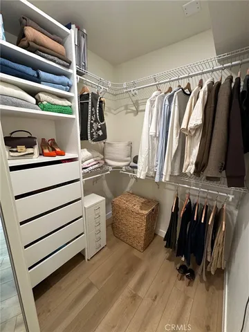 a view of walk in closet with clothes and shoes