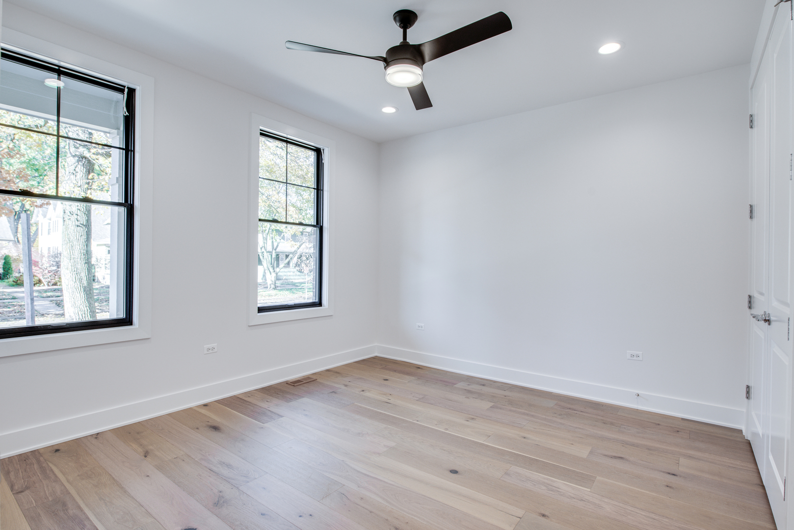 116 North Wright Street, Unit 5 Naperville, IL 60540 - Photo 45 of 62 an empty room with wooden floor ceiling fan and windows
