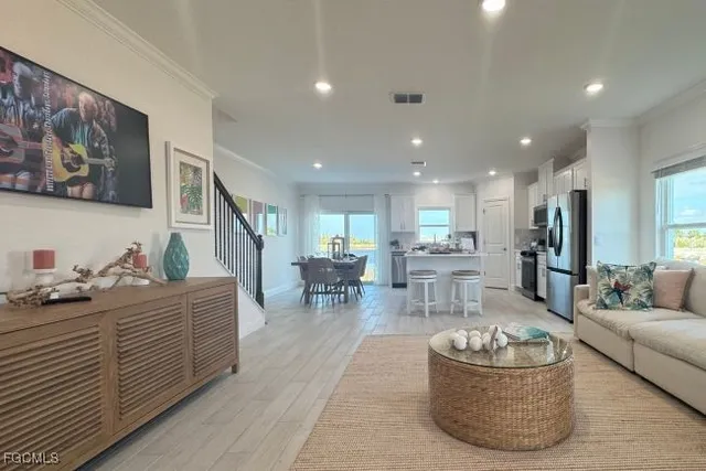 a view of a hallway to room with wooden floor and furniture