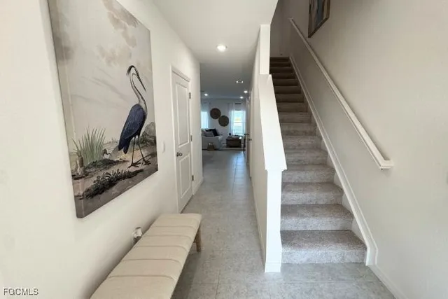 a view of a hallway to room with wooden floor and furniture